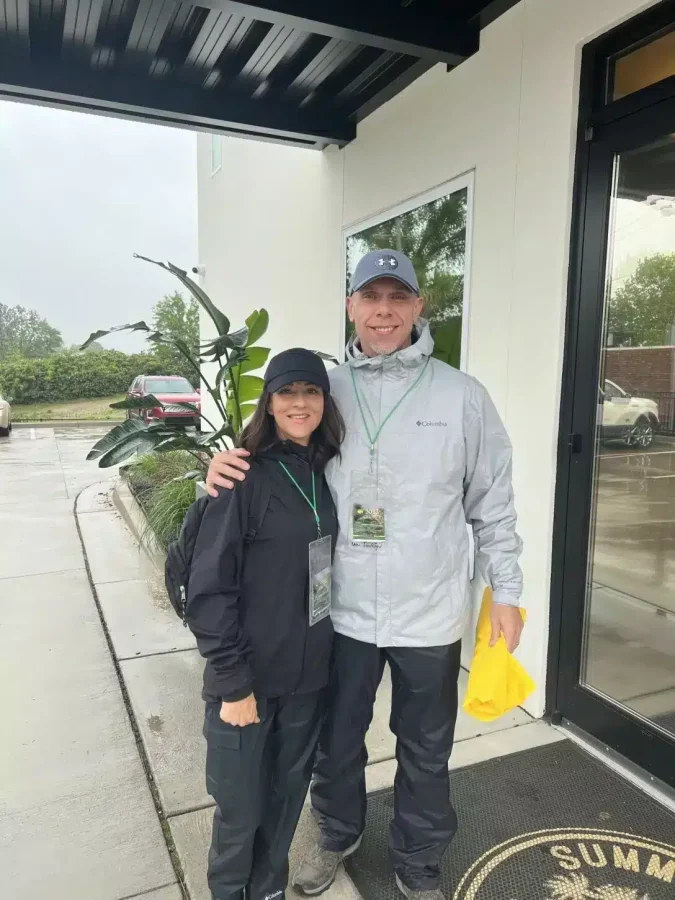 A couple standing together outside in rainy weather