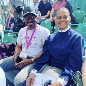 two people sitting together at a tennis event