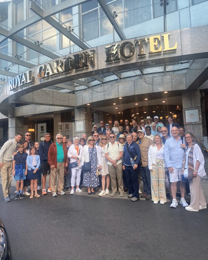 A large group of people posing in front of the Royal Garden Hotel