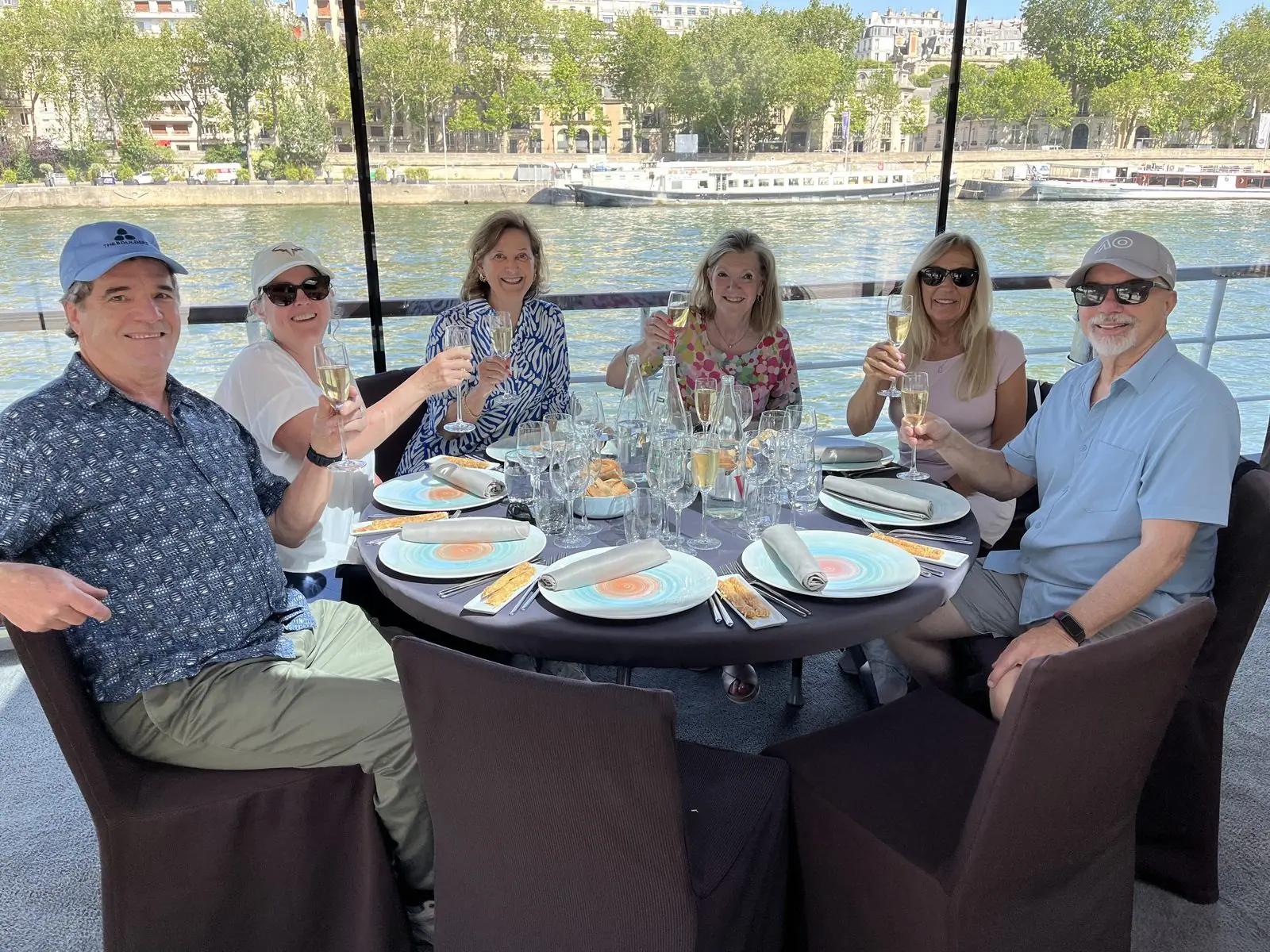MAC Sports Travel guests toast with champagne on a Seine river lunch cruise in Paris