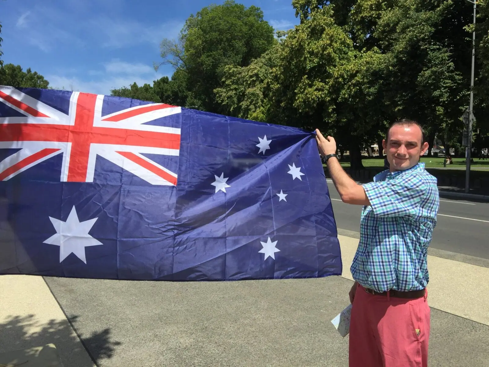 A MAC Sports Travel guest holds an Australian flag in a Melbourne park