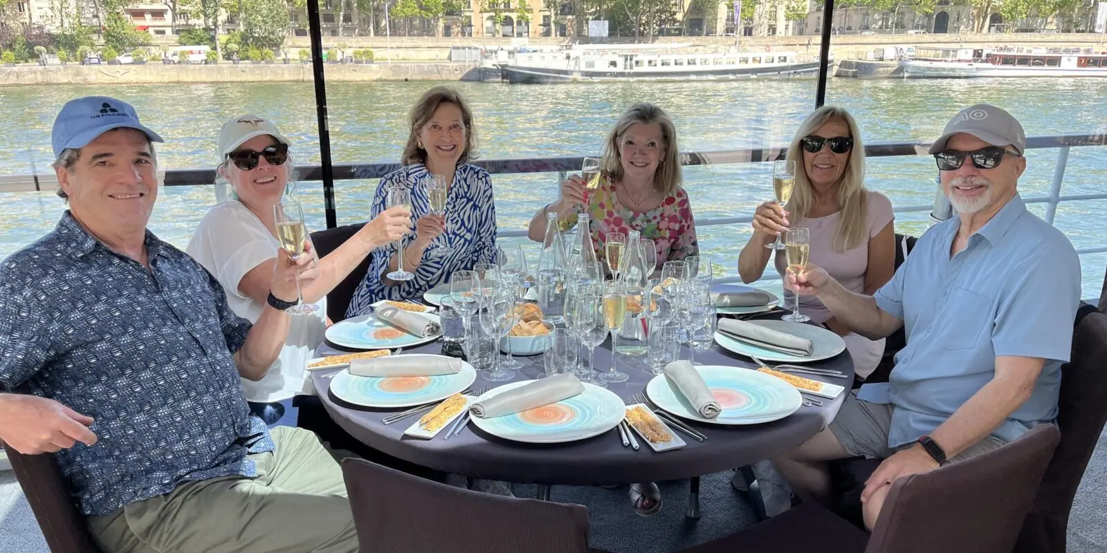 MAC Sports Travel guests raise a toast at lunch on a Seine river boat in Paris